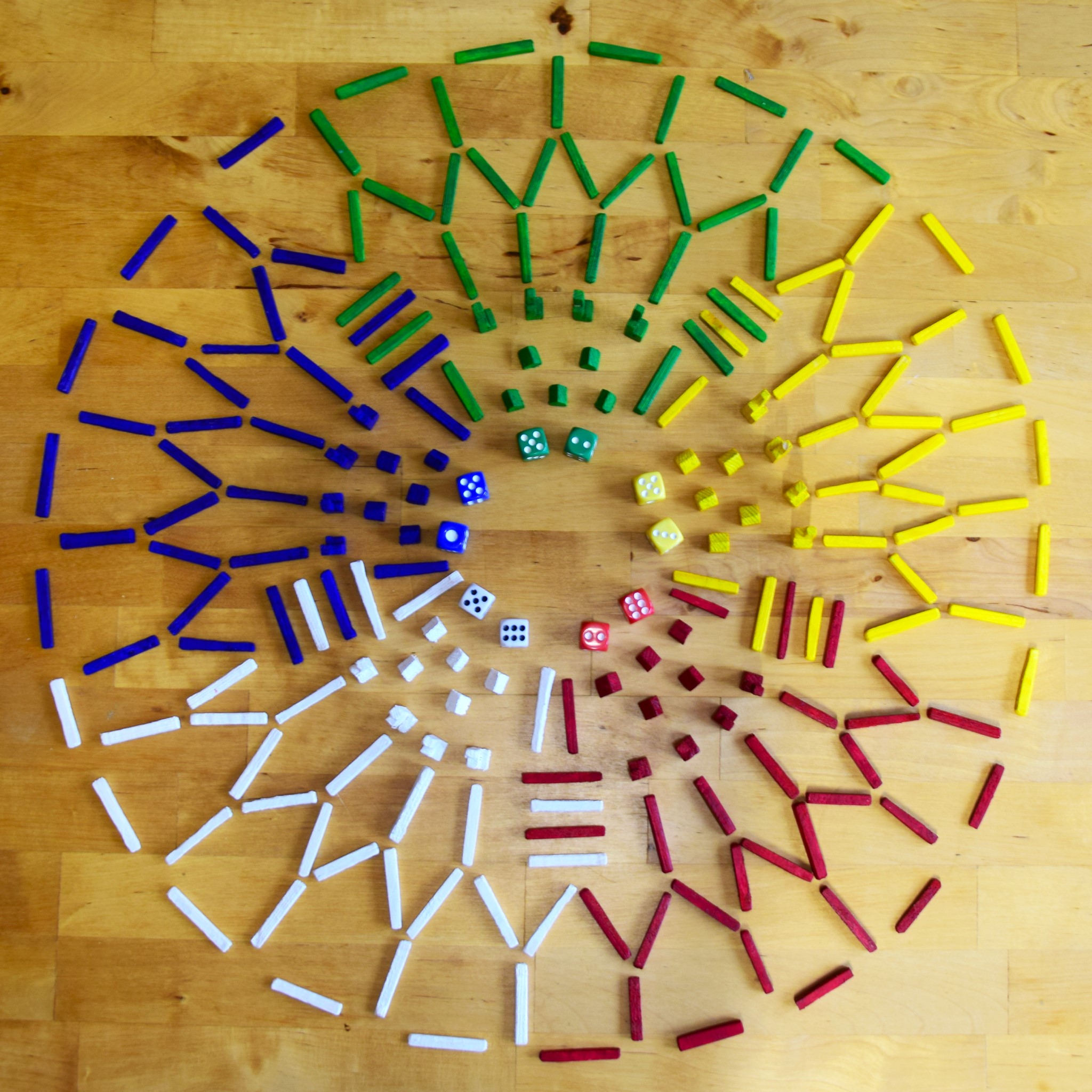 colourful wooden board game pieces spread out on a table to form a circle